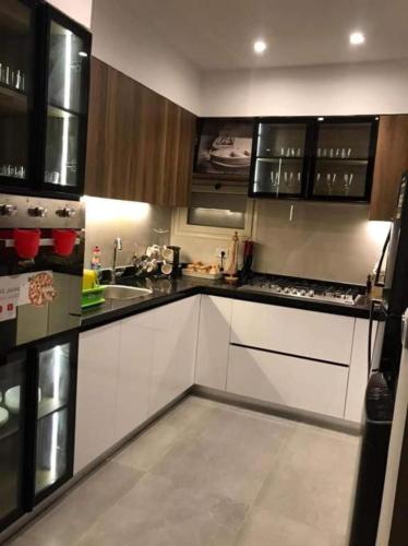 une cuisine avec des armoires blanches et des appareils électroménagers noirs dans l'établissement LINCON inn, à Aqaba