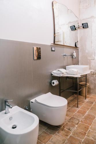 a bathroom with a toilet and a sink at Il Granile Contemporary Loft in Matera