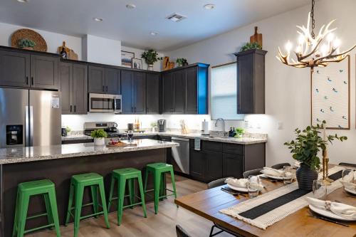 a kitchen with black cabinets and green bar stools at Adora in the Pines with Axe Throwing in Flagstaff