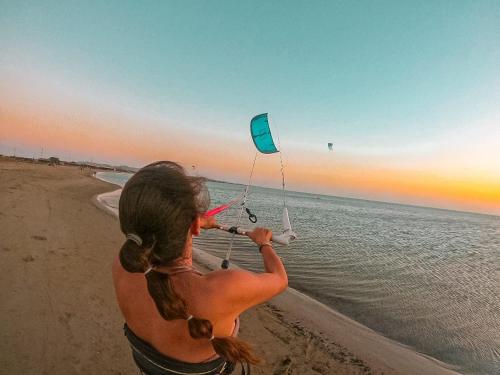 a woman flying a kite on the beach at Hotel Sukuua Kai Cabo de la vela in Cabo de la Vela
