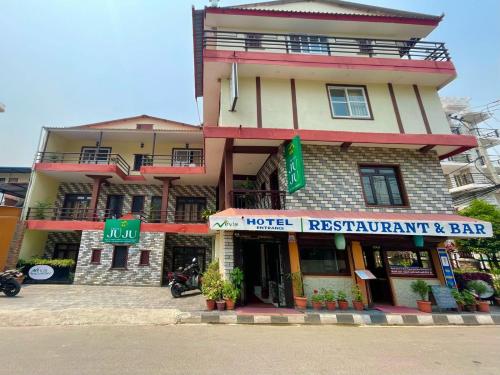 a building with a motorcycle parked in front of it at Hotel Juju in Pokhara