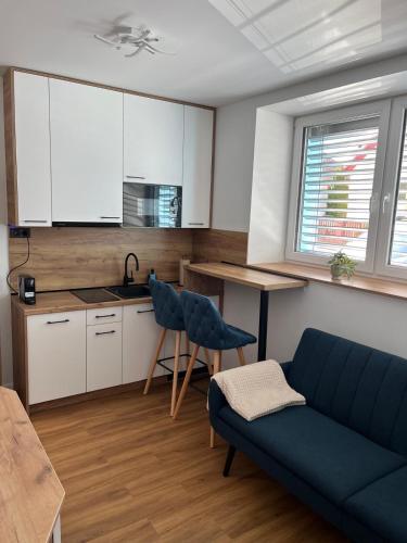 a kitchen and living room with a couch and a table at IQ Apartments in Prešov
