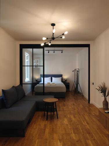 a living room with a bed and a couch at Magnolia Urban Apartments, Corfu Town in Ágios Rókkos