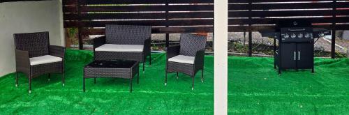 a group of chairs and a grill with green grass at Amiah's Residence - Spacious two bedroom apartment in St George in Saint Georgeʼs