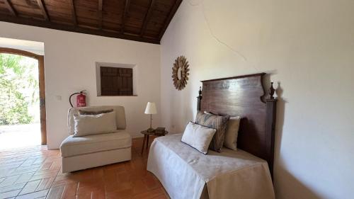 a bedroom with a bed and a chair at RIVERSIDE RANCH by Nature Bliss in Vila Nova de Milfontes