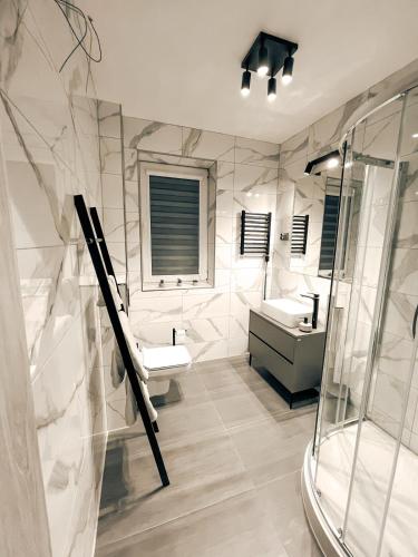 a white bathroom with two sinks and a shower at Zosieńka in Podolsze