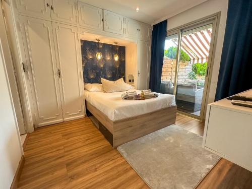 une chambre avec un lit et une grande fenêtre dans l'établissement Escapade balnéaire, Piscine privée et à deux pas des plages, à Cannes