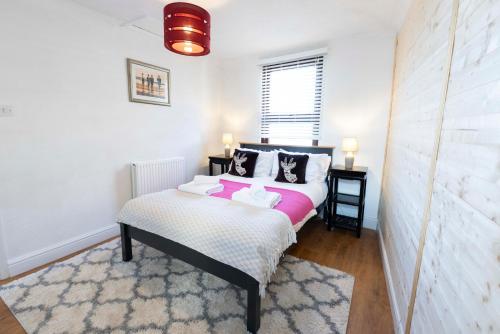 a bedroom with a bed with pink and white sheets at The Loft Apartment in Shoreham-by-Sea