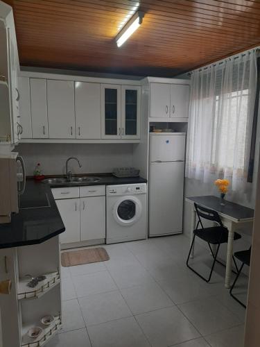 a kitchen with white cabinets and a washing machine at Casa Valeriana Guijosa in Guijosa