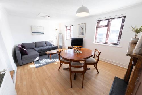 a living room with a table and a couch at The Loft Apartment in Shoreham-by-Sea