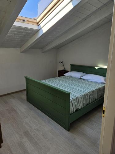 a bedroom with a green bed with a skylight at Agriturismo Palazzo Vescia in Quercia di Aulla
