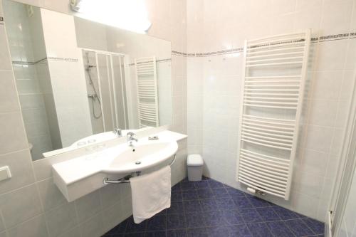 a white bathroom with a sink and a mirror at Pension Joseph Haydn in Podersdorf am See
