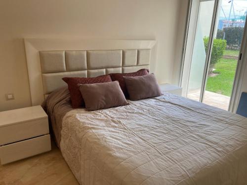 a bedroom with a large bed with a large window at CASABAY Sidi Rahal, appartement avec accès direct à la piscine in Sidi Rahal