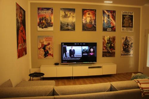 a living room with a flat screen tv on a wall with posters at Kulturelles Businessapartment in Toplage in Chemnitz