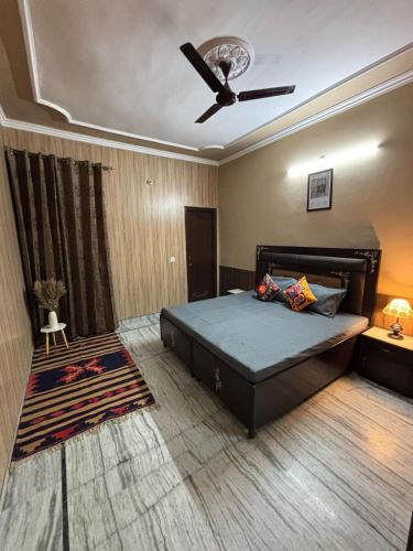 a bedroom with a bed and a ceiling fan at Whispers of Peace Villa in Amritsar
