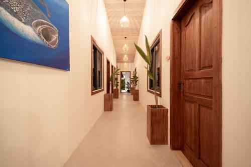 a hallway with a door and paintings on the walls at Oasis Dhigurah in Dhigurah