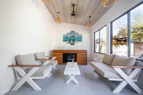 a living room with white furniture and a fireplace at Oasis Dhigurah in Dhigurah
