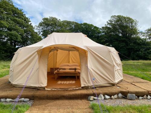 a tent with a bed in it in a field at Beautiful Bell Tent Stay in Cowbridge