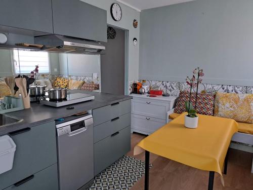 une cuisine avec une table jaune et un comptoir jaune dans l'établissement Villa Joie, à La Turballe