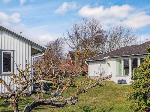 a tree in a yard next to a house at 4 star holiday home in SKÅNE VEJBYSTRAND in Vejbystrand