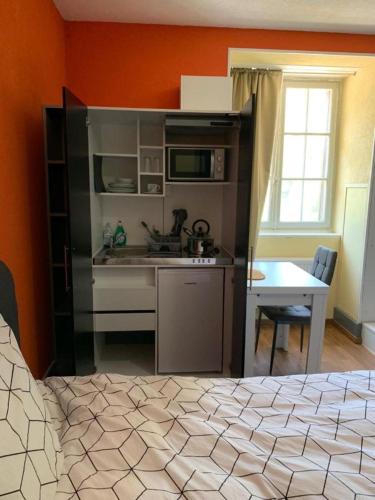 a kitchen with a bed and a table in a room at Chambre Equipè à louer in Courrendlin