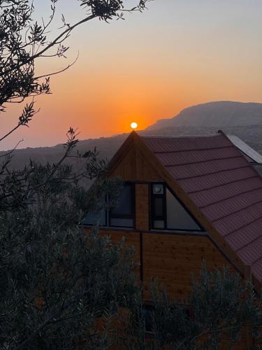 a house with the sunset in the background at Dana luxury huts in Dana