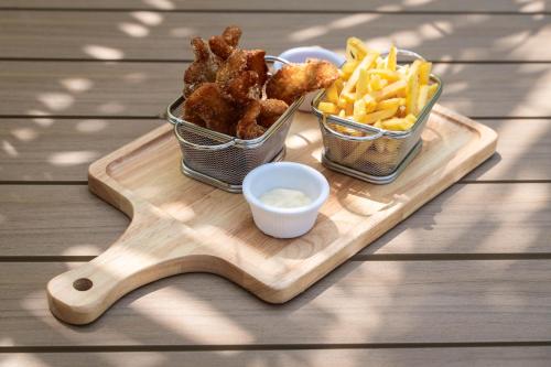 a wooden tray with three baskets of food and french fries at Oasis Dhigurah in Dhigurah