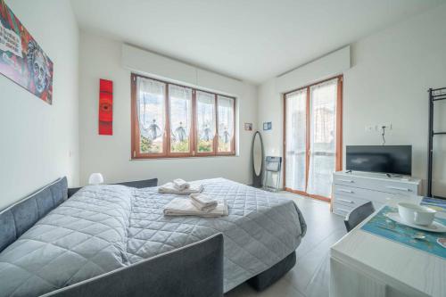 a bedroom with a large bed and a television at Einstein - Modern Apartment with Balcony in Somma Lombardo
