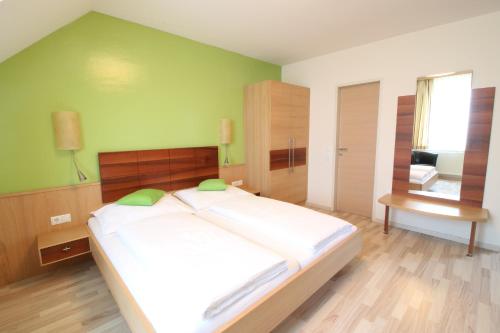 a bedroom with a large bed with a green wall at Pension Joseph Haydn in Podersdorf am See