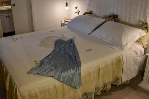 a bed with a dress sitting on top of it at Antica Casina B&B di Charme in Pulsano