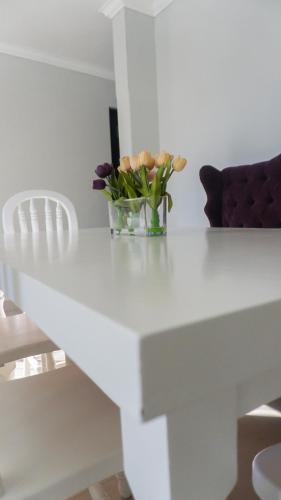 a white table with a vase of flowers on it at Valle Bonito in Los Mochis