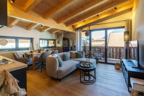 a living room with a couch and a table at Chalet Bergblick Suites - Luxury Escape in Bad Kleinkirchheim