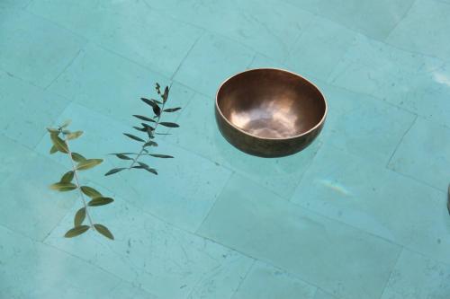 a metal bowl and a plant on a tiled floor at La Fiermontina Luxury Home Hotel in Lecce