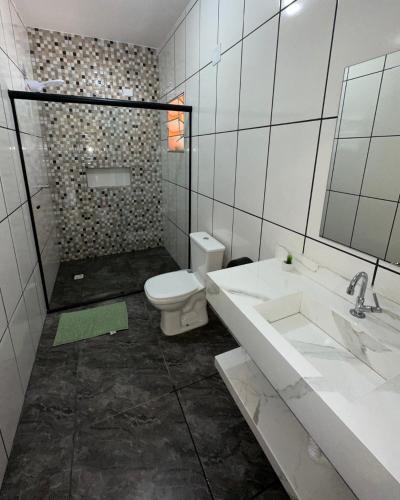 a white bathroom with a toilet and a sink at Espaço R&R 2 in São Roque