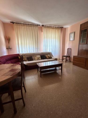 una sala de estar con un sofá y una mesa en CHUFLIS FLAt, en Argamasilla de Alba