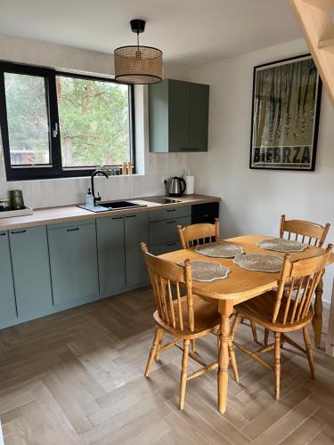 cocina con mesa de madera y sillas en Biebrzaski - dom nad Biebrzą, en Wierciszewo
