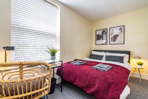 a bedroom with a bed with a red blanket at Kasu Lodge - Sneinton, Nottingham in Nottingham