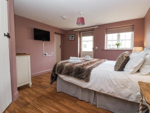 a bedroom with a large bed and a flat screen tv at The Byre in Thirsk