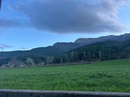 a large green field with mountains in the background at Apartamento La brisa Fiscal in Fiscal