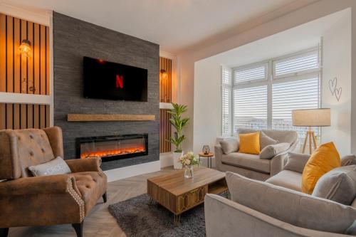 a living room with a couch and a fireplace at Swansea Waterfront View Windmill Terrace in Swansea