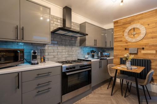 a kitchen with stainless steel appliances and a table at Swansea Waterfront View Windmill Terrace in Swansea