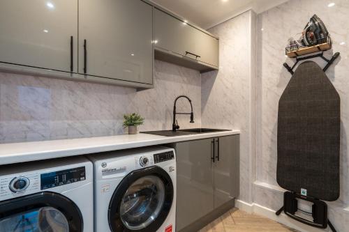 a kitchen with a washing machine and a sink at Swansea Waterfront View Windmill Terrace in Swansea