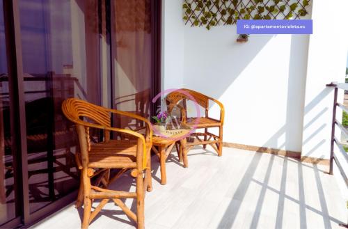two chairs and a table on a porch at Apartamento Violeta con Impresionante Vista al Mar in Playas