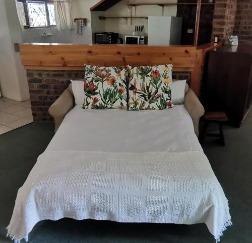 ein Bett mit einer weißen Bettdecke darauf in der Unterkunft Annasrus Mountain Cottage in Champagne Valley