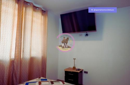 a bedroom with a bed and a tv on the wall at Apartamento Violeta con Impresionante Vista al Mar in Playas