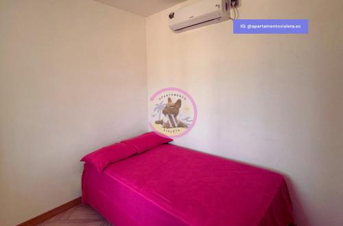 a room with a pink bed with a frisbee on the wall at Apartamento Violeta con Impresionante Vista al Mar in Playas