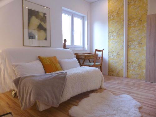 a bedroom with a white bed and a window at Ferienwohnung "Monte Noble" Südpfalz in Erlenbach