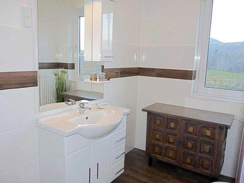 a white bathroom with a sink and a window at Ferienwohnung "Monte Noble" Südpfalz in Erlenbach