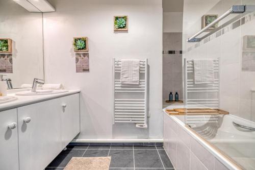 une salle de bain blanche avec un lavabo et une douche dans l'établissement T3 Disneyland et gare a pied LE DUPLEX 6 ou 7 personnes, à Serris