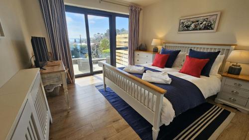 a bedroom with a bed with blue and red pillows at Chupra in Saint Mawes